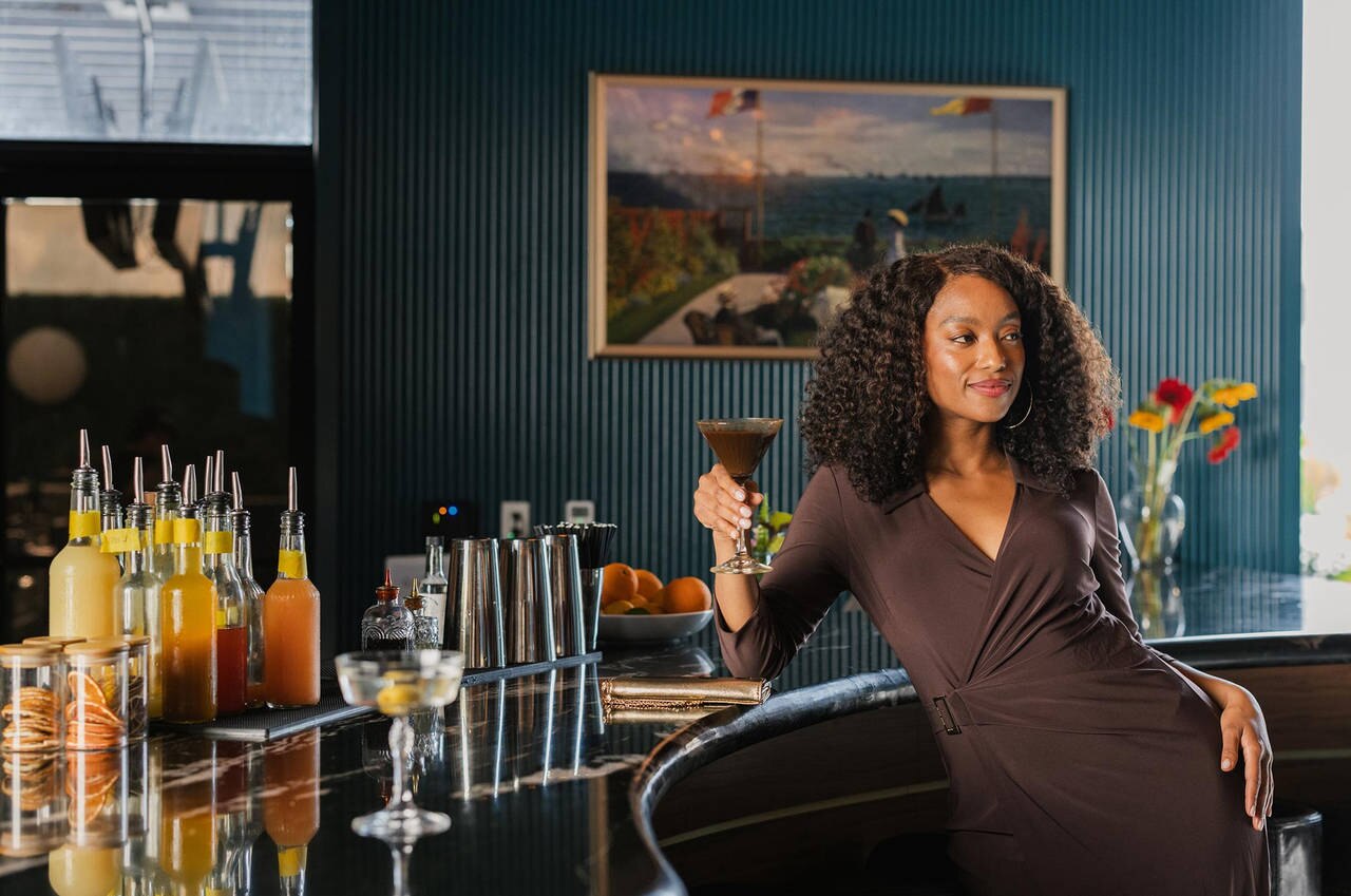 woman enjoying a cocktail at the Cambria hotel bar