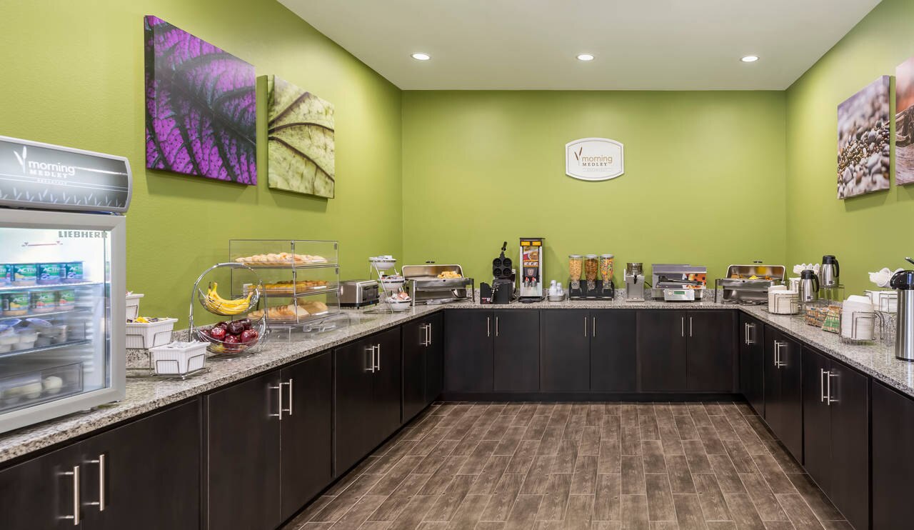 Breakfast room in hotel with food ready for guests on counter 
